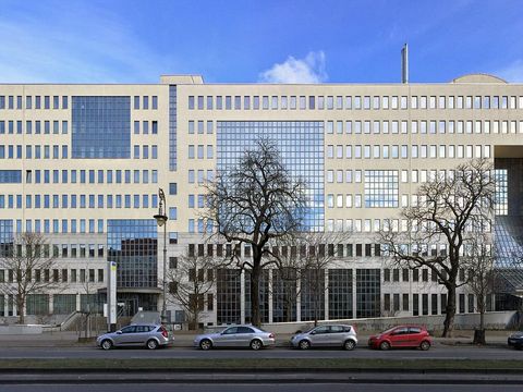 Lange helle Bürofassade der Deutschen Rentenversicherung in Berlin-Kreuzberg mit parkenden Autos