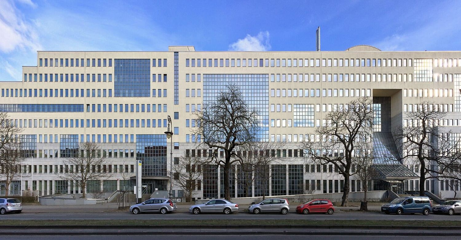 Lange helle Bürofassade der Deutschen Rentenversicherung in Berlin-Kreuzberg mit parkenden Autos