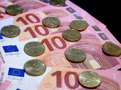 Aufgefächerte Zehn-Euro-Scheine mit darauf verteilten Zehn-Cent-Münzen