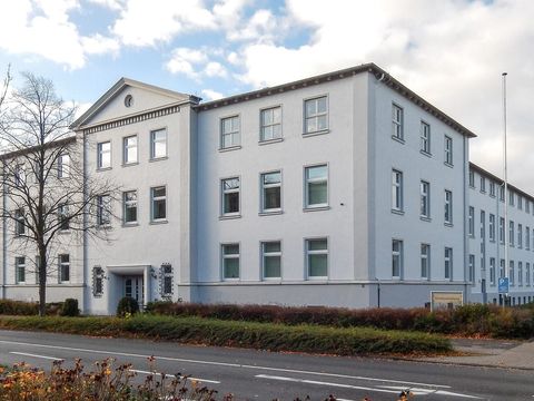 Weißes dreistöckiges Verwaltungsgebäude der Künstlersozialkasse in Wilhelmshaven an einer Straße