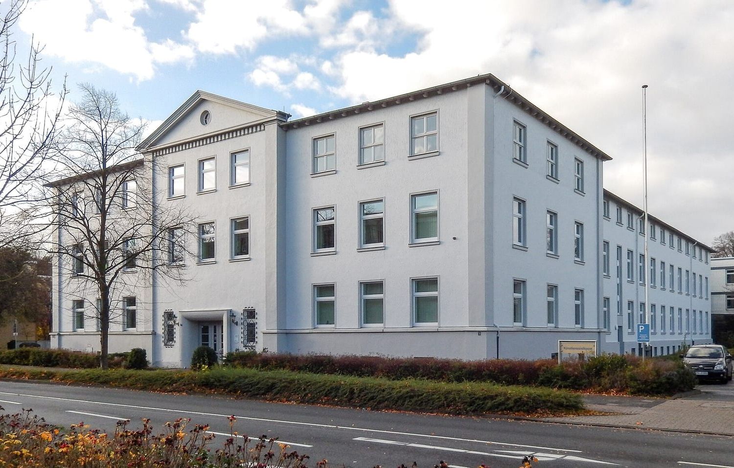 Weißes dreistöckiges Verwaltungsgebäude der Künstlersozialkasse in Wilhelmshaven an einer Straße