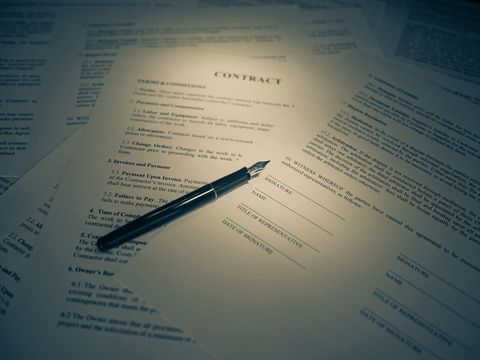 Ausgedruckter Vertrag mit Unterschriftszeilen, darauf ein schwarzer Füllfederhalter