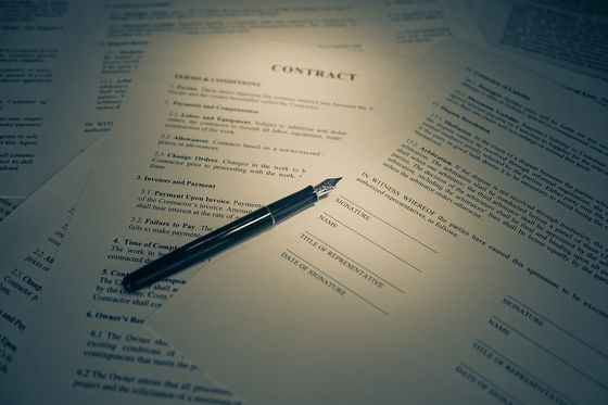 Ausgedruckter Vertrag mit Unterschriftszeilen, darauf ein schwarzer Füllfederhalter
